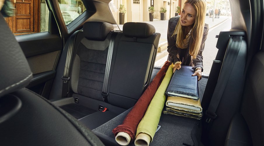 SEAT Serwis – przeglądy i konserwacja – kobieta umieszczająca rzeczy w bagażniku samochodu ze złożonymi siedzeniami
