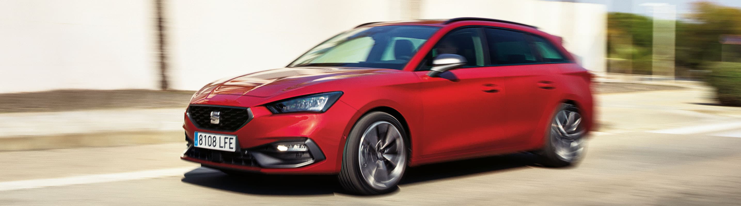Seat Leon w kolorze Desire Red w ruchu podczas słonecznego dnia.