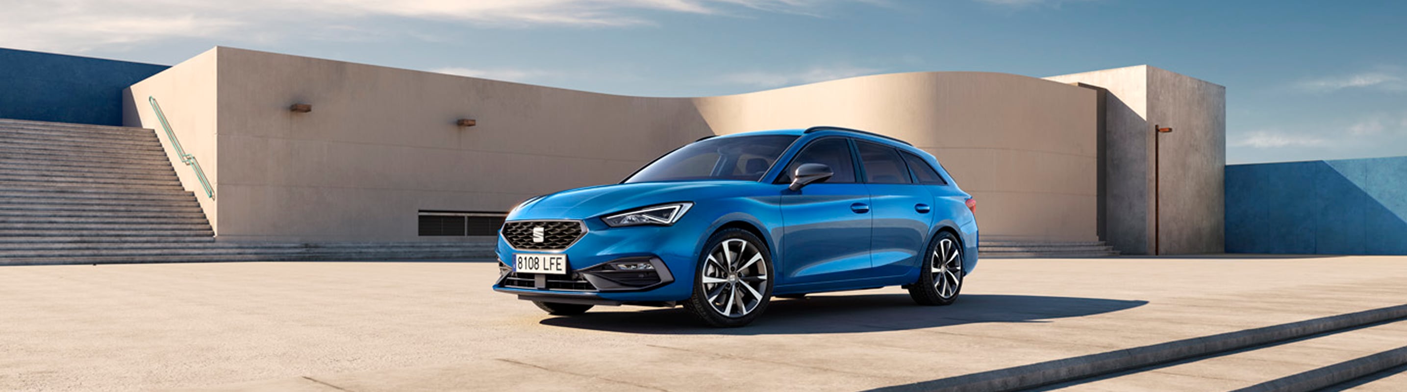 Czarny SEAT Leon e-HYBRID podłączony do ładowarki, widziany z boku. 