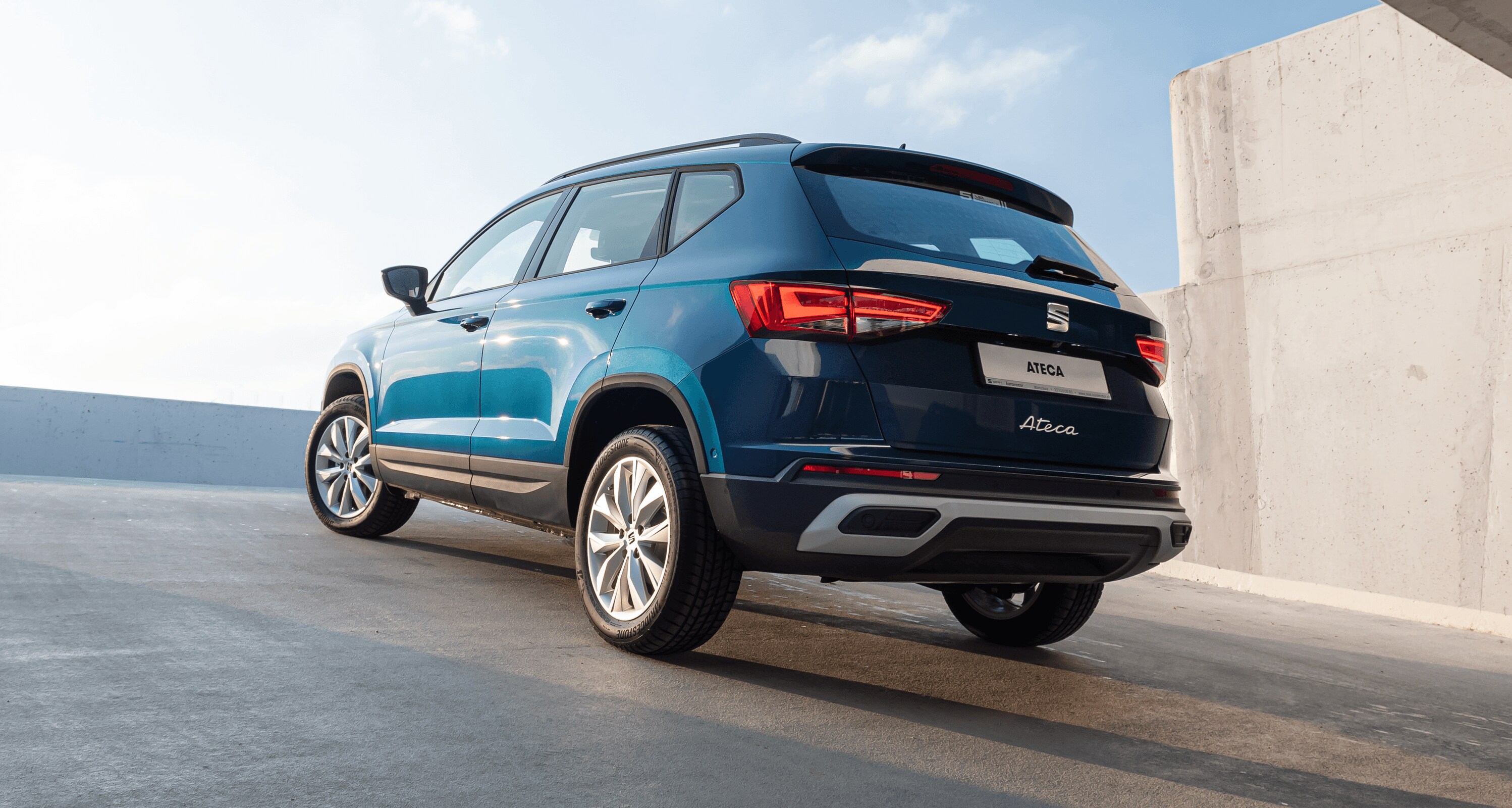 SEAT Arona w kolorze Lava Blue, metalizowany. Widok z tyłu na lewy profil. Światło dzienne.