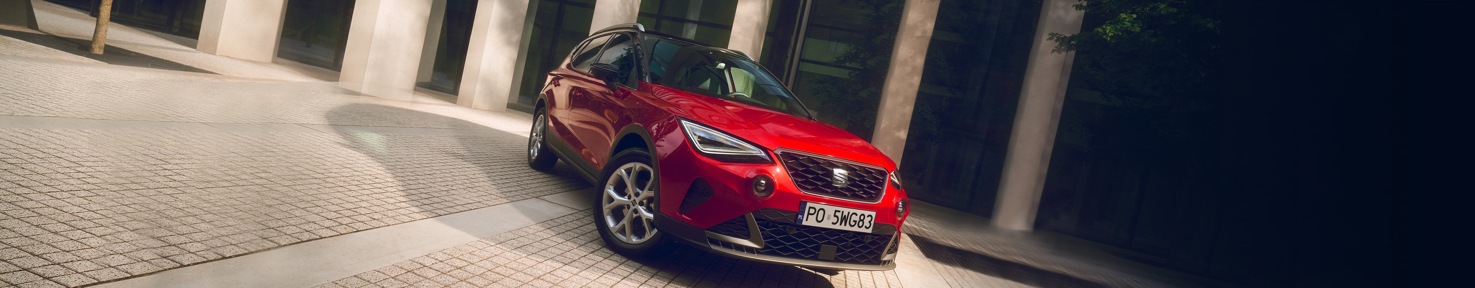 SEAT Arona w kolorze Desire Red widok z przodu na prawą stronę auta.