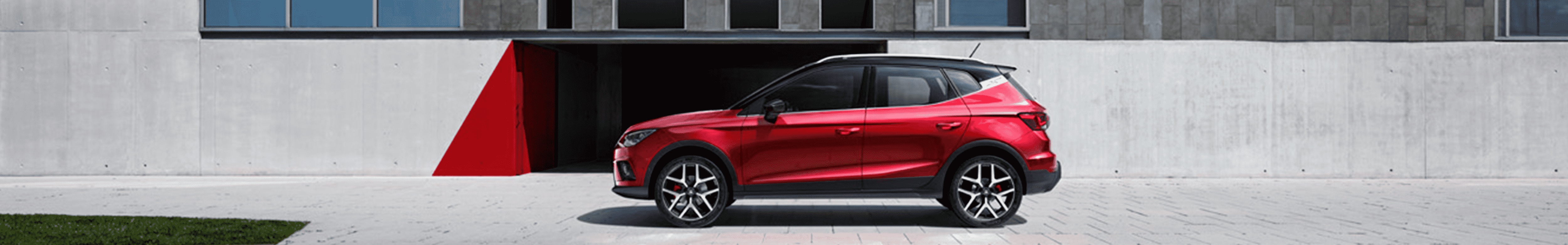 SEAT Arona w kolorze Desire Red w miejskim otoczeniu, widok z boku