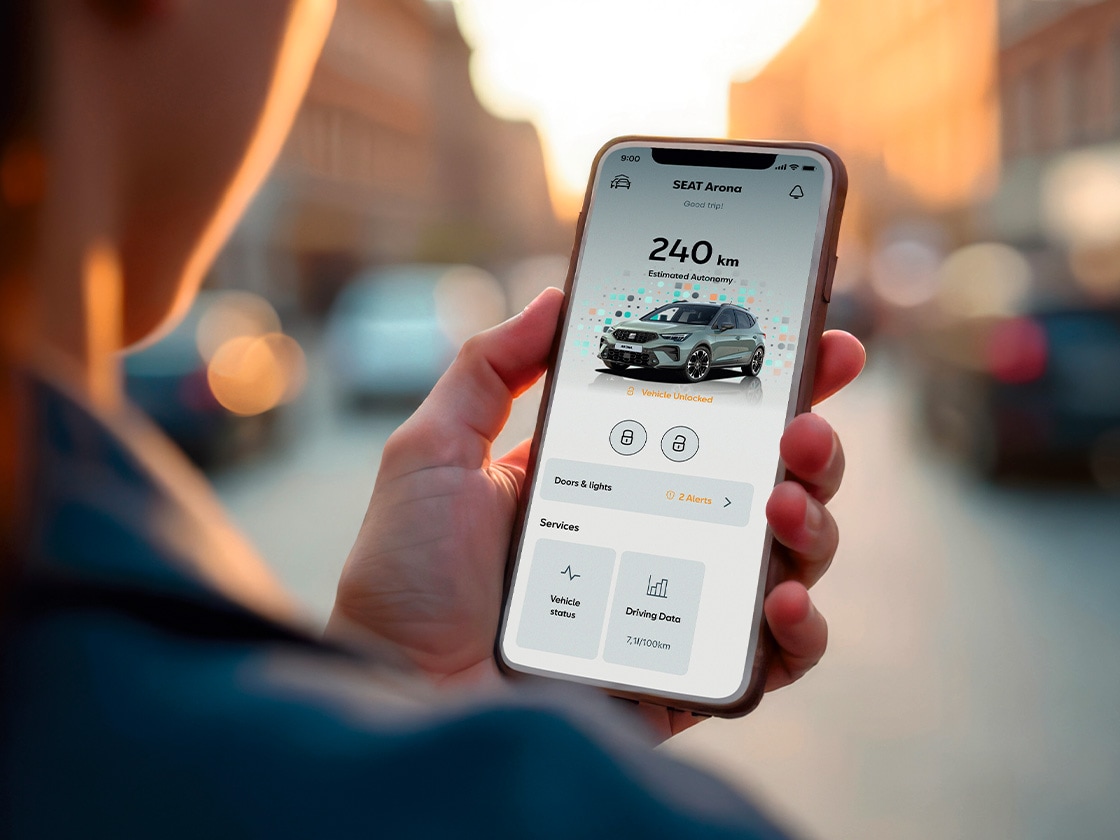 Mężczyzna używa smartfona, aby pokazać, jak łatwo można uzyskać zdalny dostęp do samochodu, dzięki aplikacji My SEAT App.