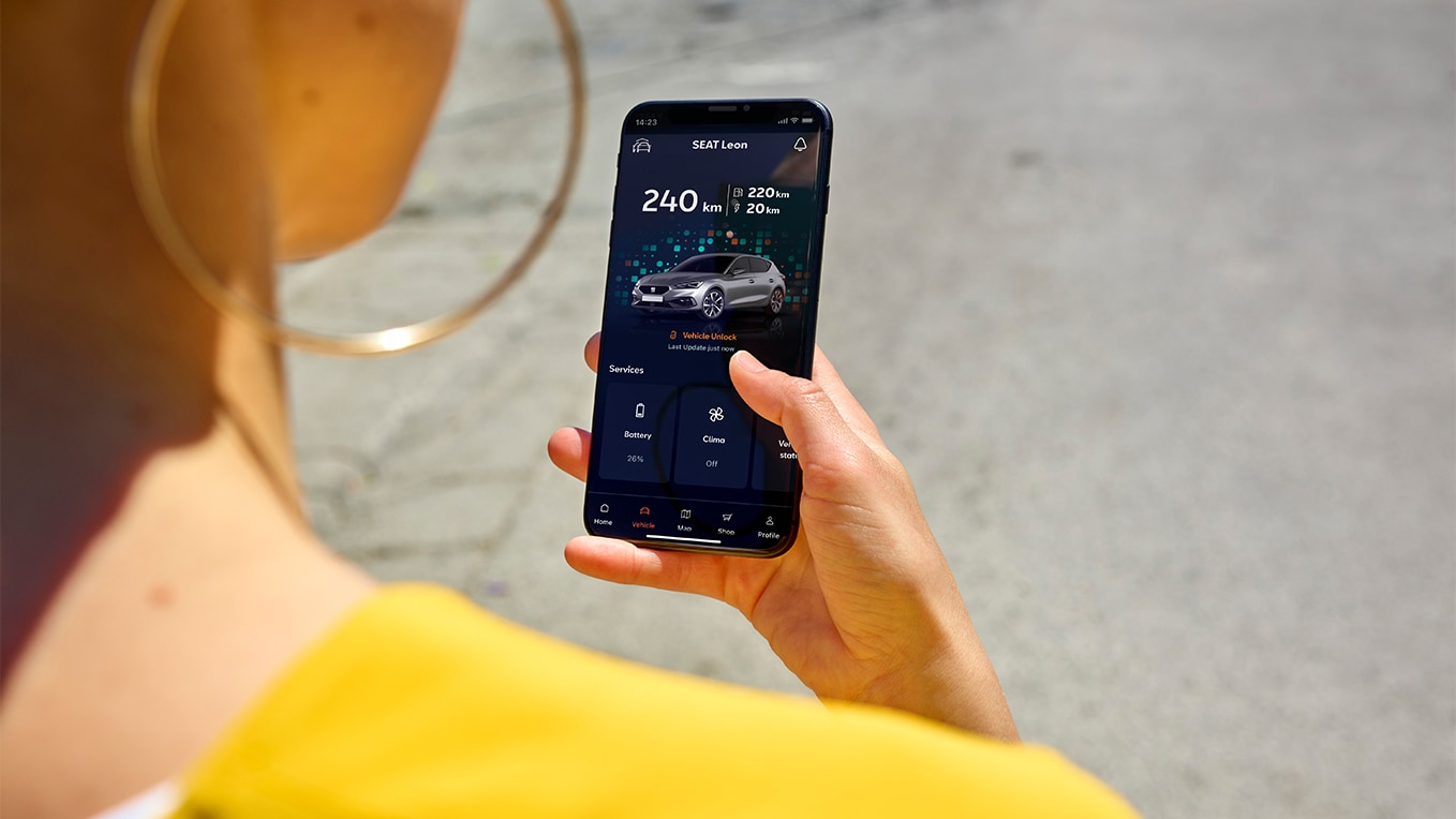 Osoba trzymająca smartfon korzystająca z aplikacji my seat, funkcji seat connect, umożliwiającej zdalny dostęp i korzystanie z funkcji pojazdu.