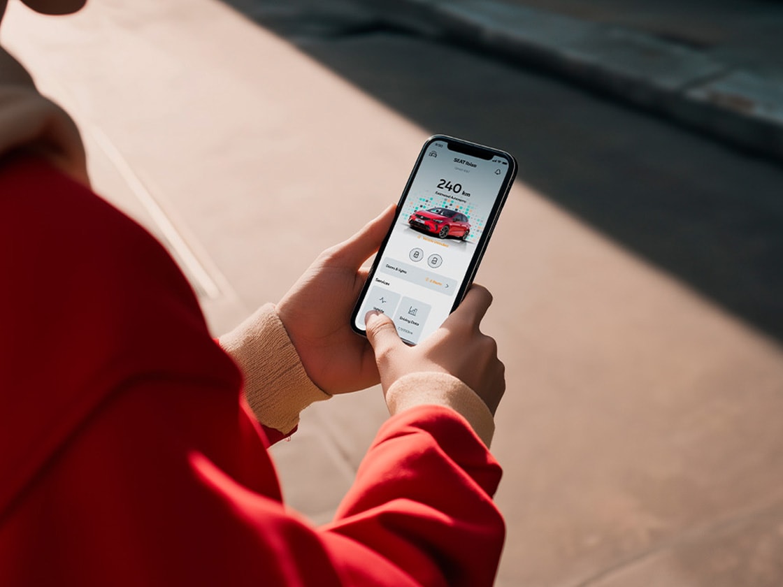 Osoba trzymająca smartfon i sprawdzająca system SEAT Connect.