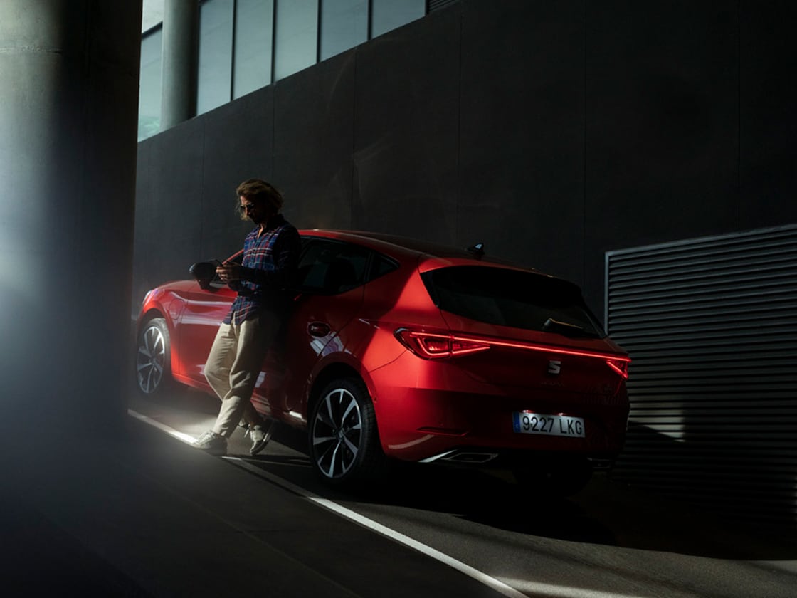 Czerwony samochód w zaśnieżonej górskiej scenerii z ubezpieczeniem pojazdu.