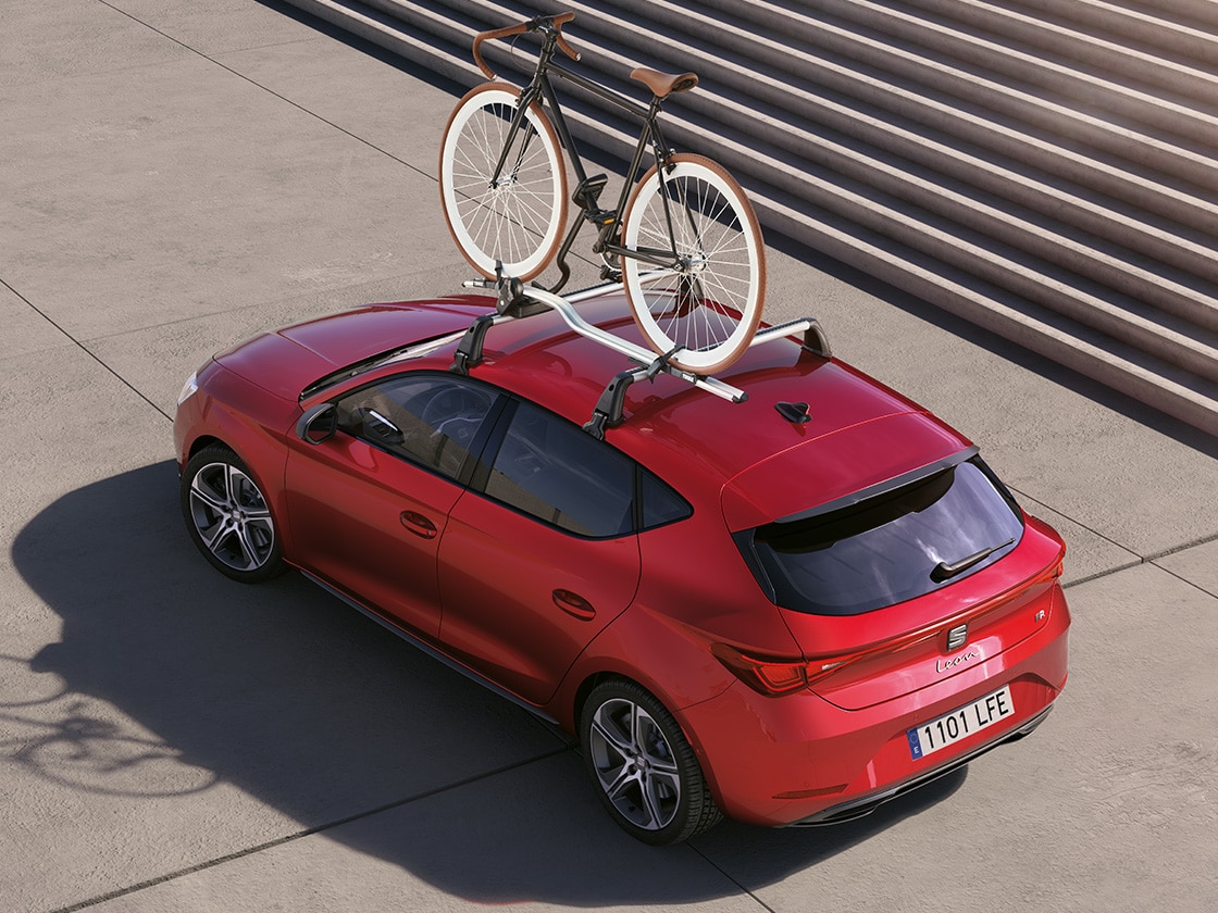 Czerwony SEAT Leon wyposażony w bagażnik rowerowy, idealny do przewożenia roweru i odkrywania nowych miejsc. Idealny do 5-drzwiowych modeli z gamy.