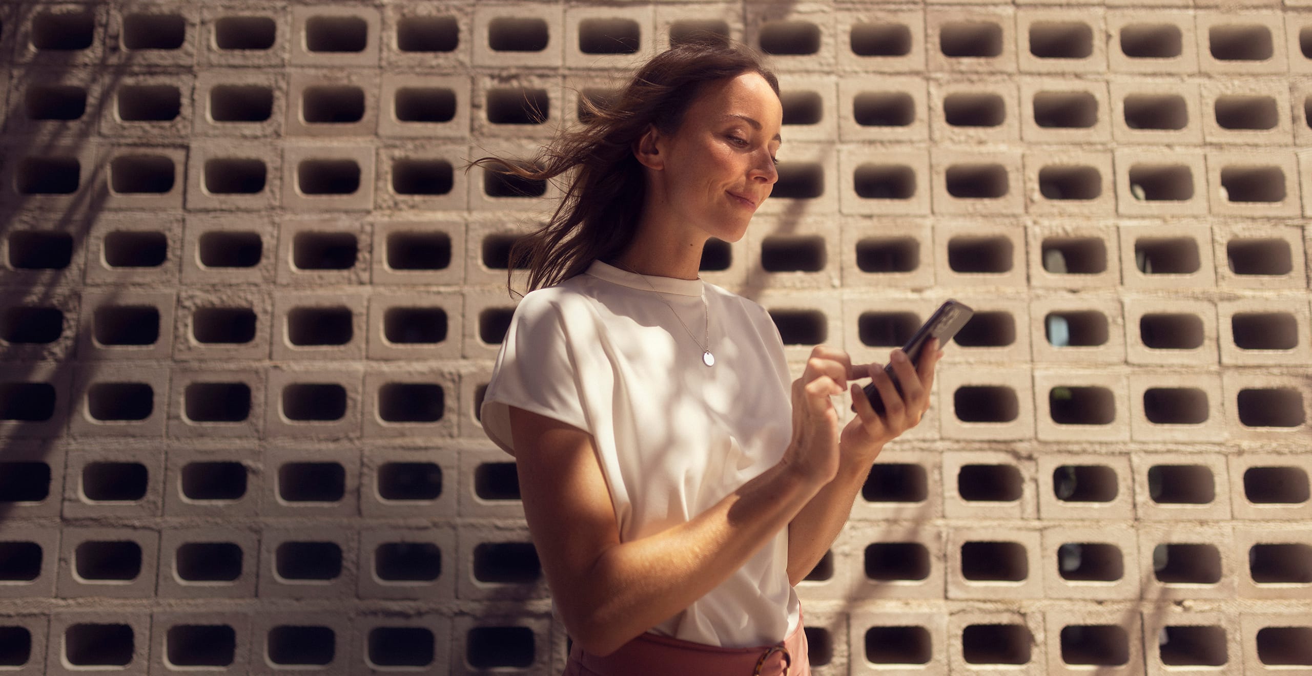 kobieta trzyma smartfon z uruchomioną aplikacją seat connect