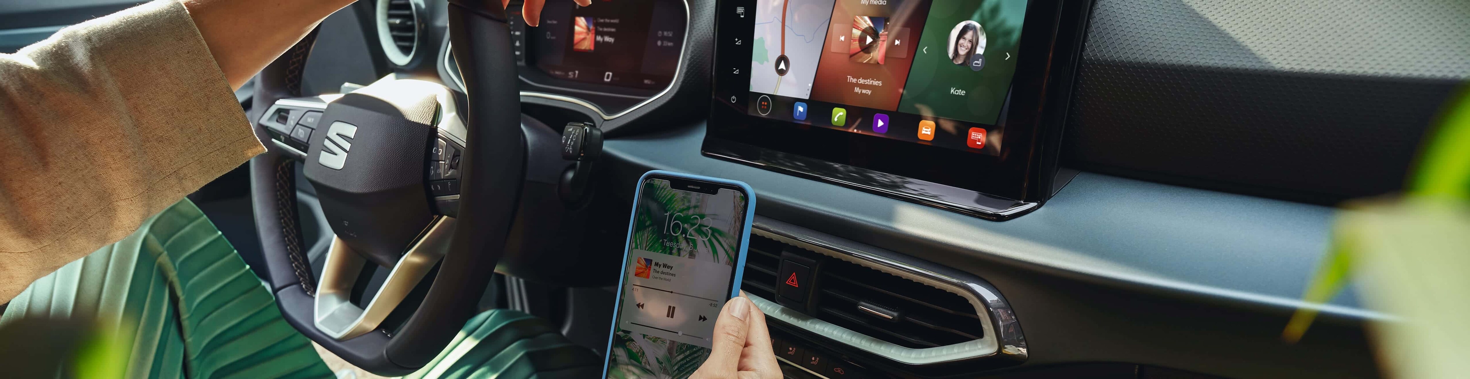 wnętrze SEAT-a Arona i siedząca kobieta, która łączy się z SEAT CONNECT