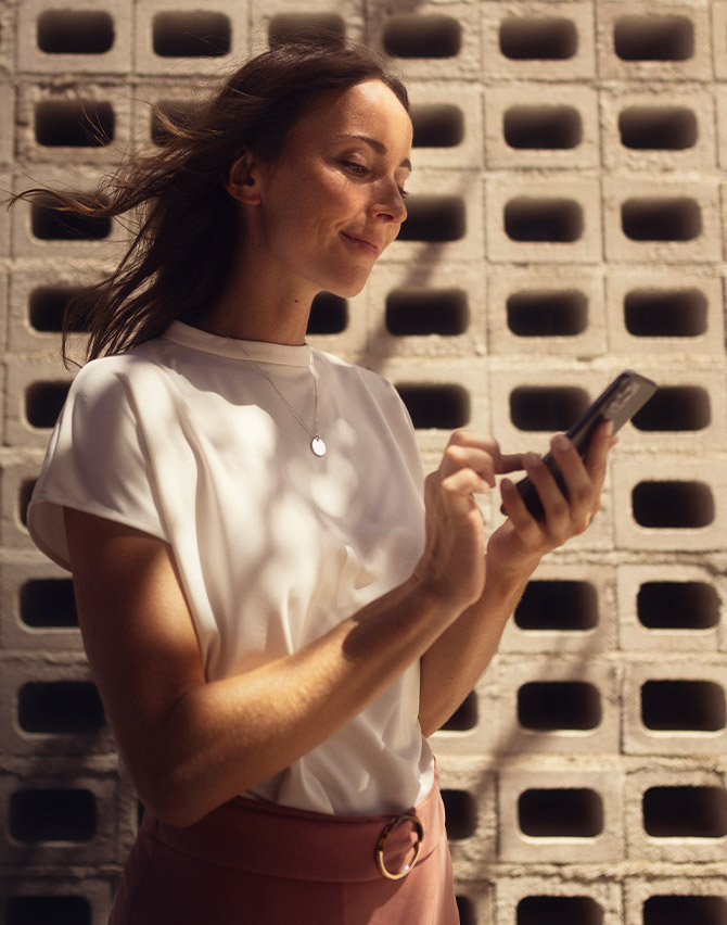Kobieta korzystająca ze smartfona z aplikacją SEAT Connect