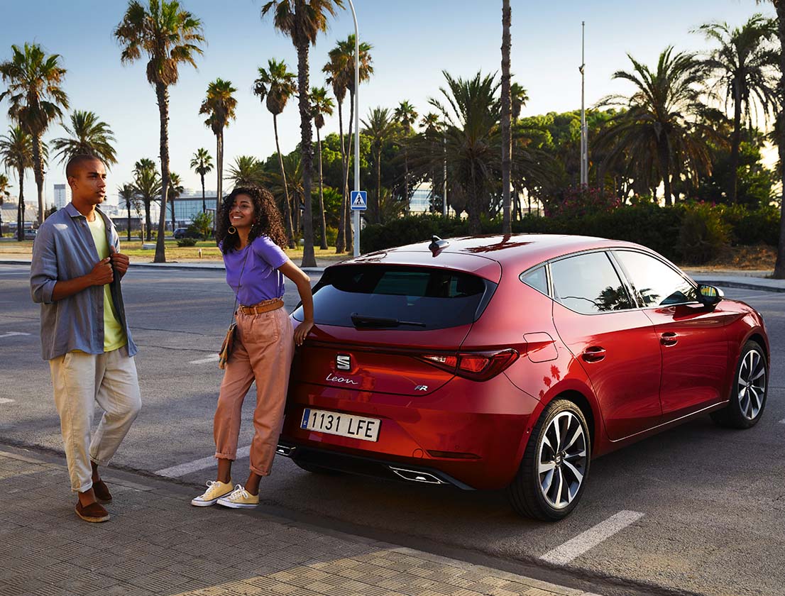 Czerwony SEAT Leon zaparkowany na miejskim parkingu 