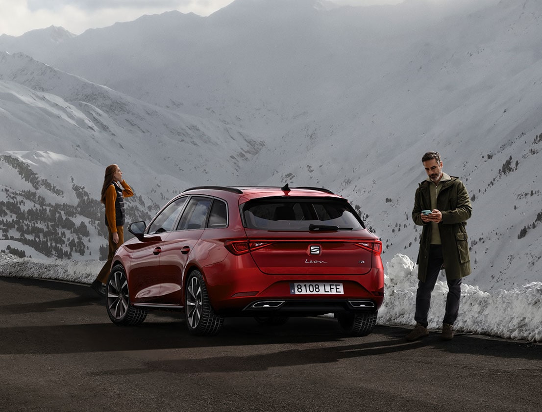 SEAT Leon Sportstourer zaparkowany na drodze w pobliżu ośnieżonych wzgórz