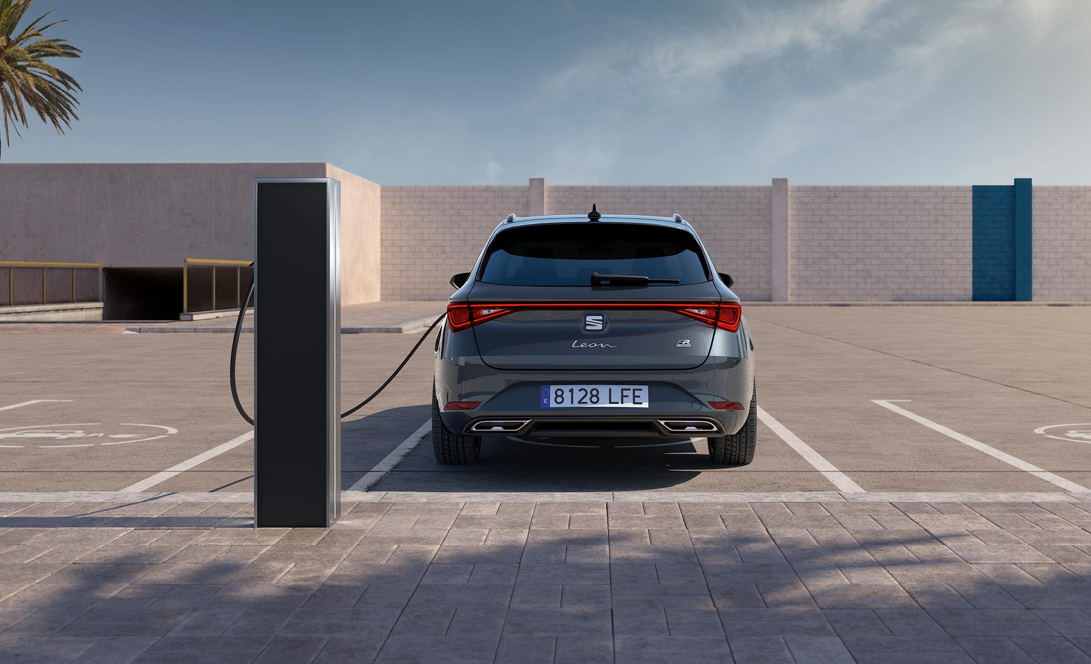 Widok z tyłu na nowego SEATa Leona e-HYBRID Sportstourer 2020, podłączonego do ładowania w specjalnie wyznaczonym miejscu