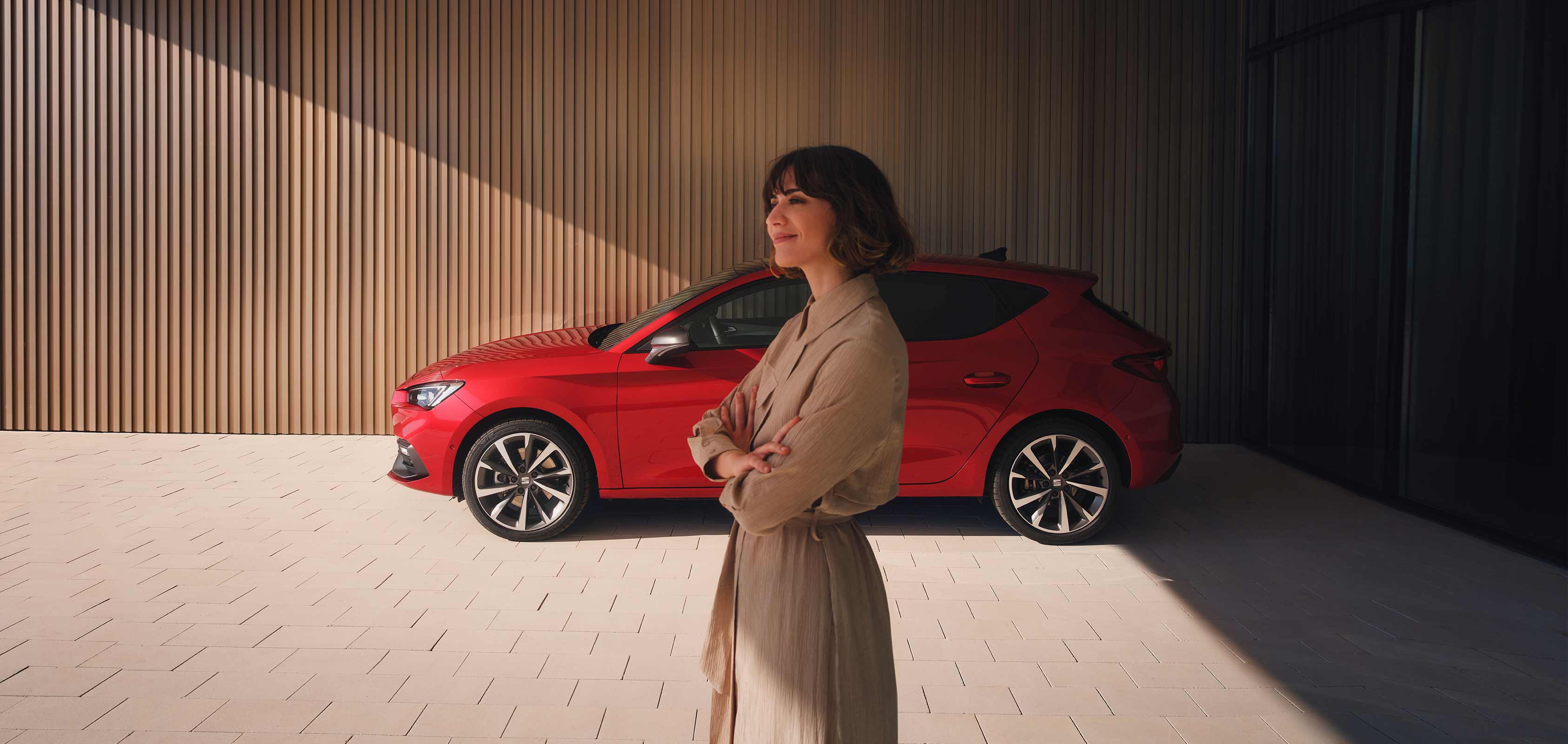 Mężczyzna stojący na tle nowego SEAT-a Leona w kolorze Desire Red